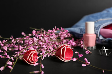 Set of female accessories and flowers on dark background, closeup