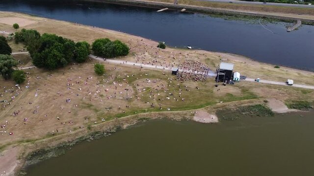 Music festival in two river conjunction with crowd of people, aerial drone view
