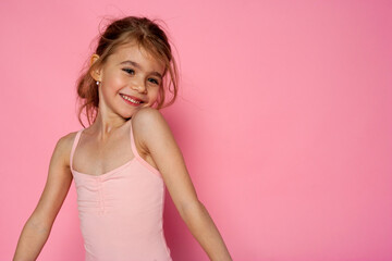 Attractive girl having fun on the pink background.