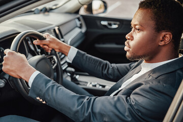 Fototapeta na wymiar Businessperson of african descent sitting inside car