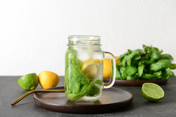 Mason jar of lemonade with basil on light background