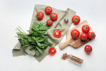 Naklejka na ściany i meble Fresh ripe tomatoes, spices and basil leaves on light background