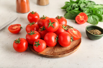 Plate with fresh ripe tomatoes, spices and basil leaves on light background