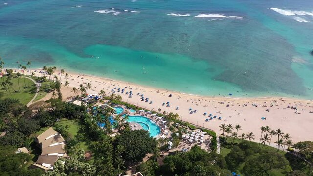 Cinematic 4K aerial drone pan shot of the Hale Koa Hotel resort pool, hotels, condos on the West side of Waikiki near Honolulu on Oahu island, Hawaii known for its popular surfing and beaches