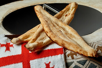 Traditional Georgian bread shotis puri with national flag on tone oven