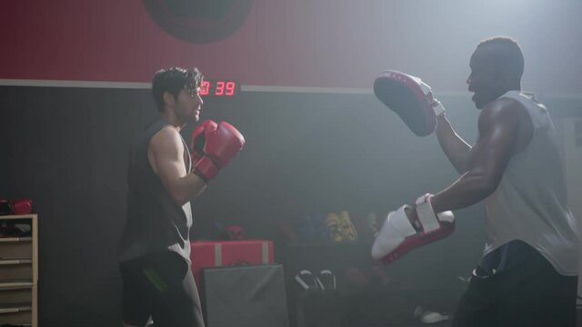 Fitness boxer trainer motivate sportsman exercise boxing, punch at gym