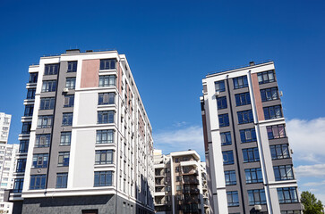 Fototapeta premium Modern European residential apartment buildings quarter on a sunny day with a blue sky. Abstract architecture, fragment of modern urban geometry
