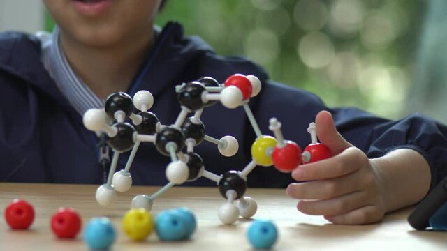 Asian Child Constructing Molecular Model In Science Classroom
