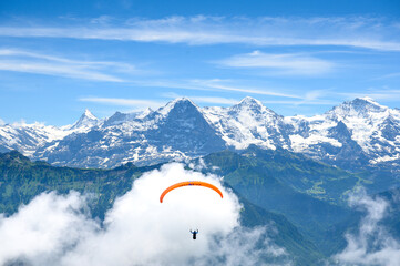 paraglide flyer in the Bernese Alps in front of Eiger Mönch and Jungfrau