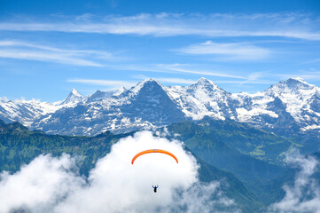paraglide flyer in the Bernese Alps in front of Eiger Mönch and Jungfrau