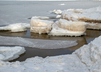 winter landscape by the sea, snowy, interesting ice shapes on the sea shore, dunes covered with a white layer of shining snow