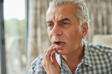 Mature Man At Home Suffering From Pain With Toothache