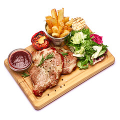 Grilled roated beef steaks, potato, sauce and salad on wooden cutting board