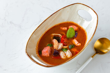 Asian Tom Yum soup in bowl on gray table
