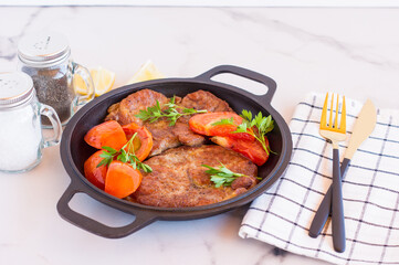 Roasted pork steaks in frying pan from neck meat. light wooden background.