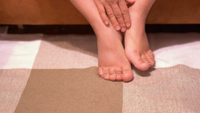 A woman touches her swollen legs with her hand. Pregnancy in the last stages. High quality 4k footage