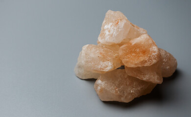 Large crystals of pink salt on a gray background. High quality photo