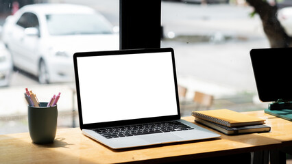 Laptop blank screen on wooden table in coffee shop