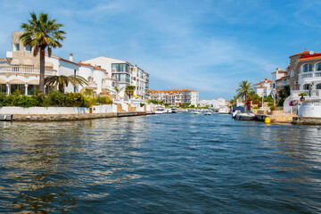 Fototapeta na wymiar Beautiful and cozy resort town, Empuriabrava town in summer atmosphere, canal with yachts and small boats, Costa Brava, Catalonia