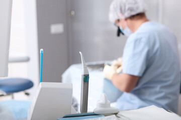 Dentist with binocular glasses at work. Vertical photo on a light background. Preparation for the...