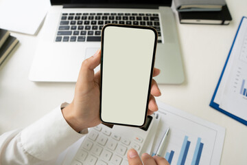 businessman hands using smartphone mockup at the white office desk. Blank screen mobile phone for graphic display montage,clipping path.