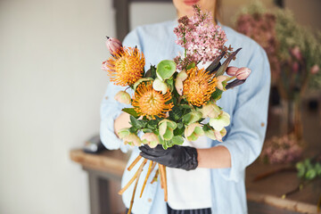 Professional florist showing a spring floral arrangement - obrazy, fototapety, plakaty