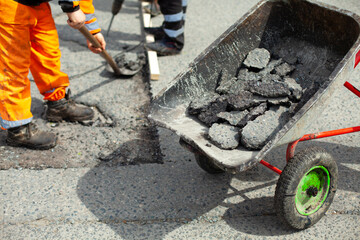 Trolley with asphalt. Road repair. Construction waste trolley.