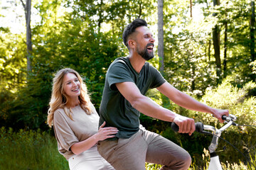 Fototapeta premium Happy couple having fun on a bike in nature