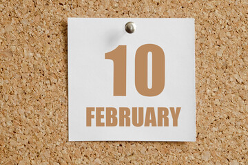 february 10. 10th day of the month, calendar date.White calendar sheet attached to brown cork board.Winter month, day of the year concept
