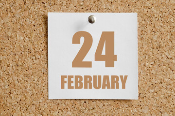 february 24. 24th day of the month, calendar date.White calendar sheet attached to brown cork board.Winter month, day of the year concept
