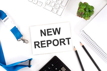 NEW REPORT Words on the card with keyboard and office tools, business