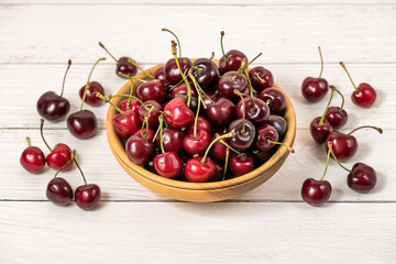 Fototapeta na wymiar Bowl full of ripe red dark cherries on wooden table surface as Source of vitamins, organic food