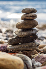 Fototapeta na wymiar Stone stacking, stones swaying in balance on beach. Close up.