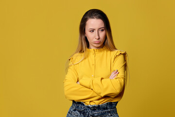 upset unsatisfied woman on yellow background. Human emotions