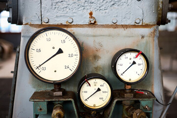 Retro style equipment of chemical plant three pressure gauges or manometers shows zero closeup with out of focus abstract industrial background with copyspace.