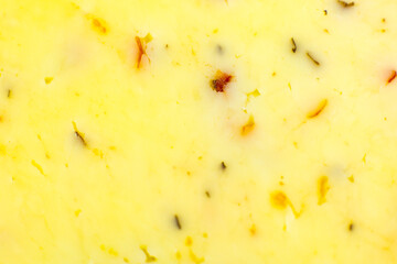 Yellow cheese with herbs and spices background Texture . Close up, macro photo.