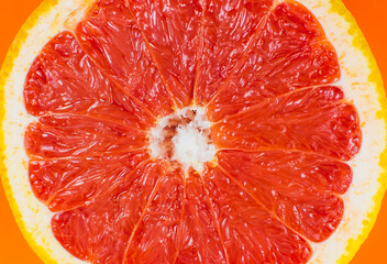 Grapefruit texture inside on the orange background. Citrus close up photo. Healthy food. Awesome wallpaper. Vegetarian and vegan concept. Vitamins from nature. Minimalism, original beautiful photo.