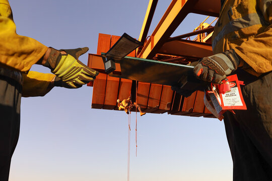 Miner supervisor dress as work uniform hand over task safety isolation permit lock box board and working at heights document to workmate during shift changing rope access abseiler working background 