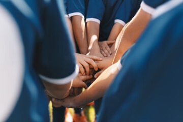 Sports team stacking hands together in a group. Happy children teammates motivated in a team. Team...