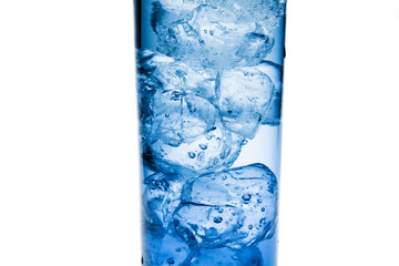 Fragment close-up. A clear blue glass beaker with clear water and ice cubes.