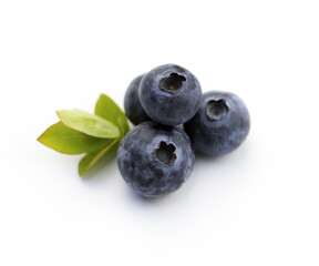 Blueberries on a white background. Berries and leaves isolated on white background. Four berries with green leaves.