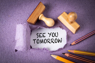 See you tomorrow. Wooden stamps and pencils on purple paper - obrazy, fototapety, plakaty