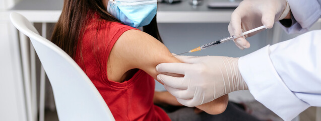 Little girl receiving coronavirus vaccine at doctor's office
