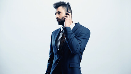 focused call center operator touching headset while talking isolated on white