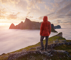A tourist enjoying a view at the Mountain Hesten, Senja, Norway. Trekking in Norway, active life concept