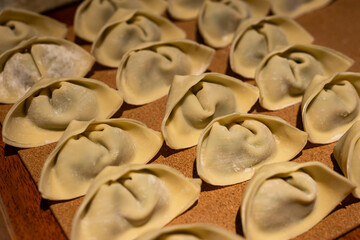 Freshly homemade dumplings on tray, home cooking concept. Shallow depth of field.