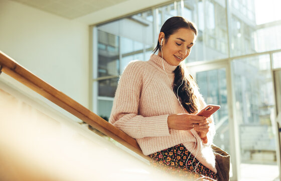 Female student using cell phone in college