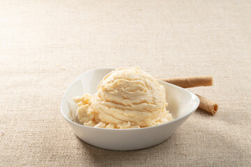 Bola de vainilla en cuenco con palitos de oblea. Vanilla ball in bowl with wafer sticks.