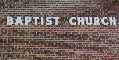 Brick Wall With Baptist Church Sign on Small Rural Church