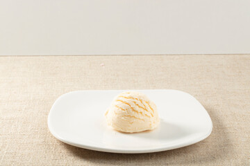 Bola de vainilla sobre plato y mantel. Vanilla ball on plate and tablecloth.